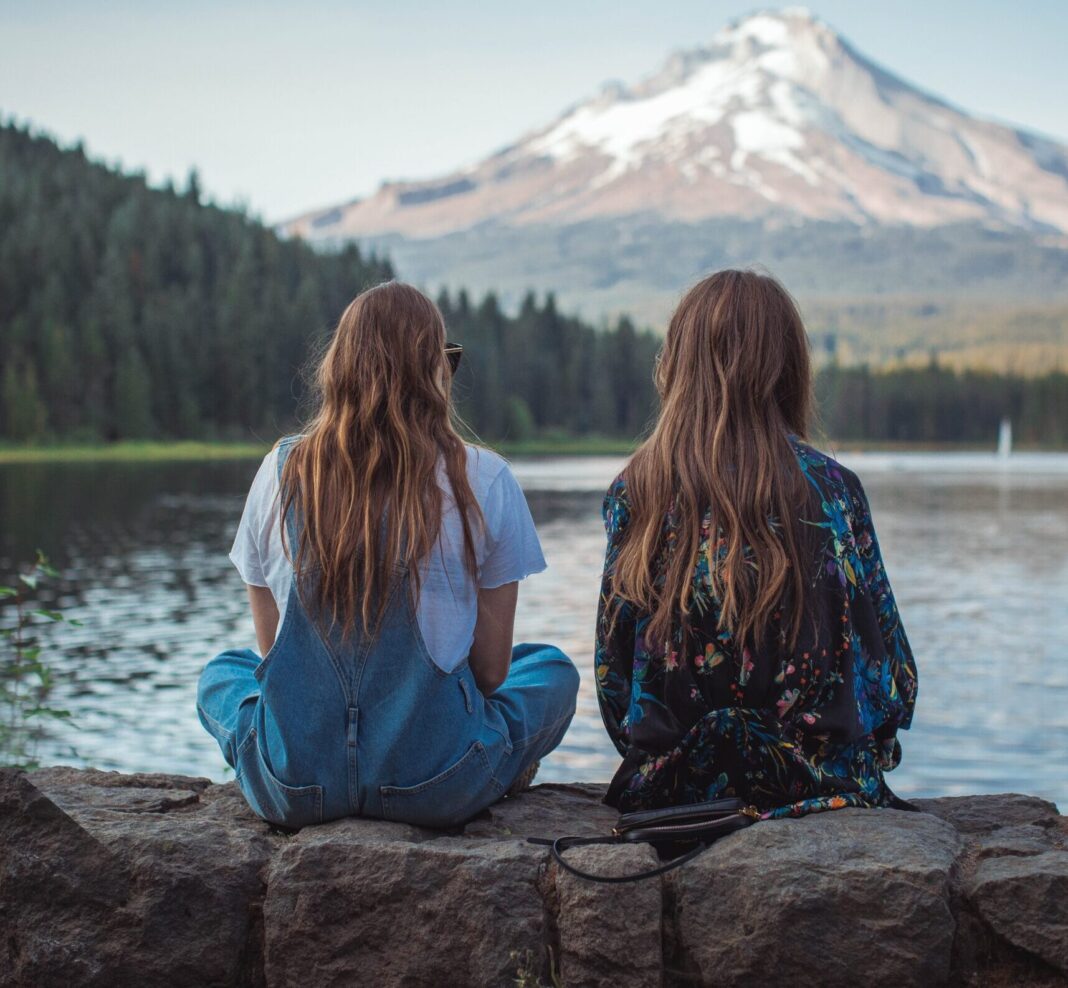 Friends sitting by mountain
