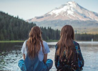 3 Practical Tips For Traveling On a Budget Friends sitting by mountain