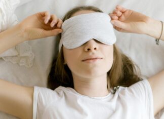 Best Sleep Masks For A Peaceful Flight Woman wearing a sleeping mask