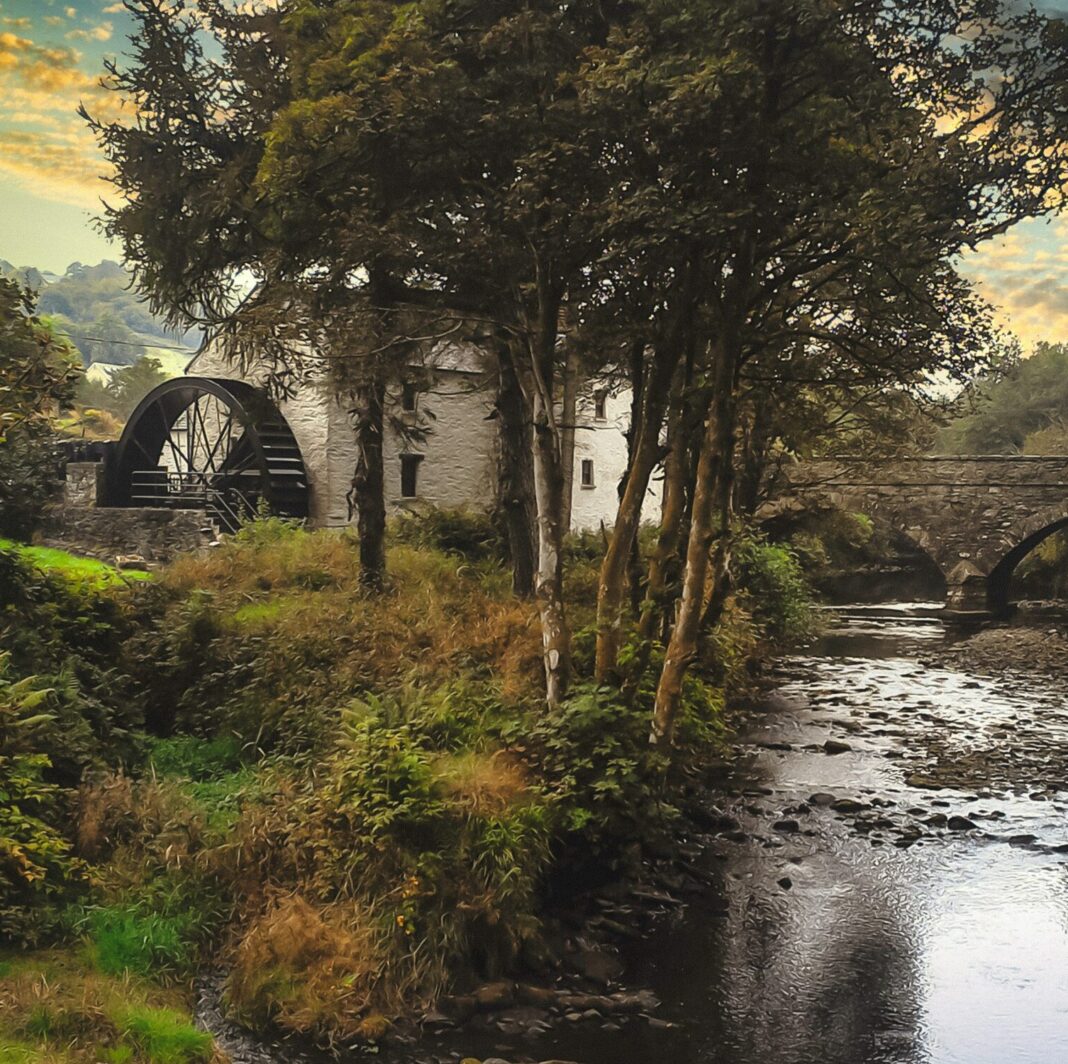 Water wheel and old stone bridge along a river in County Donegal, Republic of Ireland at sunset