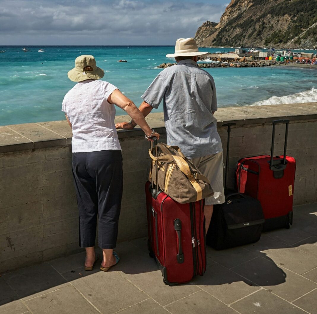 Couple with luggage on an Italian beach