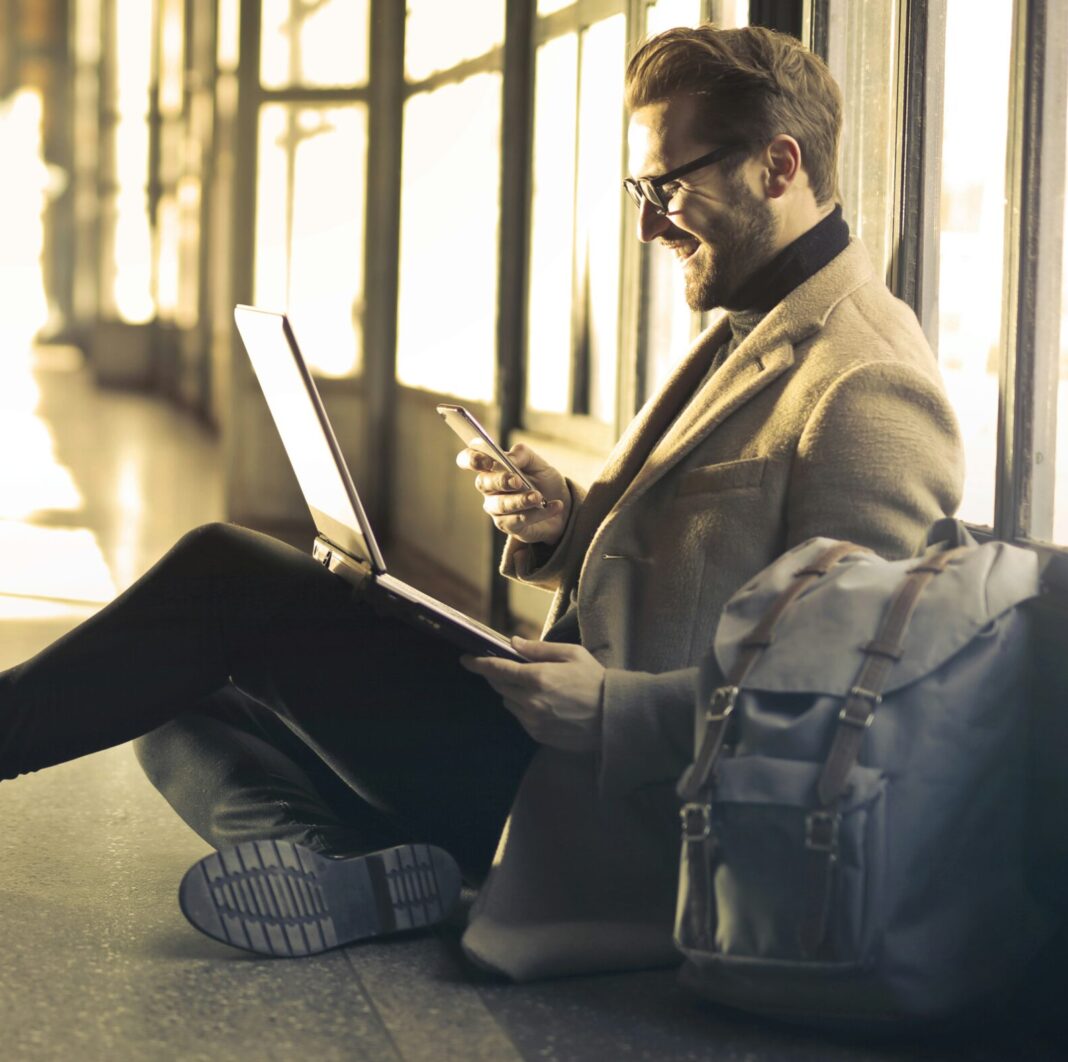 Man sitting on the ground using a laptop