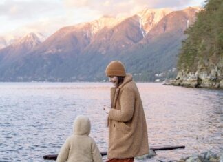 3 Reasons Why Fall Vacations Are the Best Mother and faceless little child on rocky shore near lake and mountains