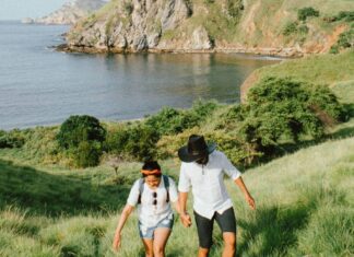 4 Tips for Choosing the Perfect Honeymoon Destination Couple climbing up a hill