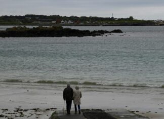 Try These Walks in the UK for Incredible Sunrises A couple walking by the shore