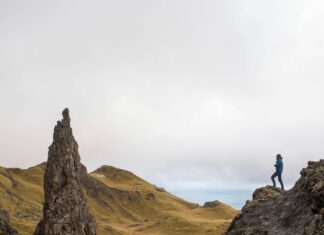 What to Wear for a UK Hiking Vacation Woman standing on a cliff