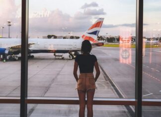 What to Wear on a Long-Haul Flight Photo of Woman Standing Near Glass Wall